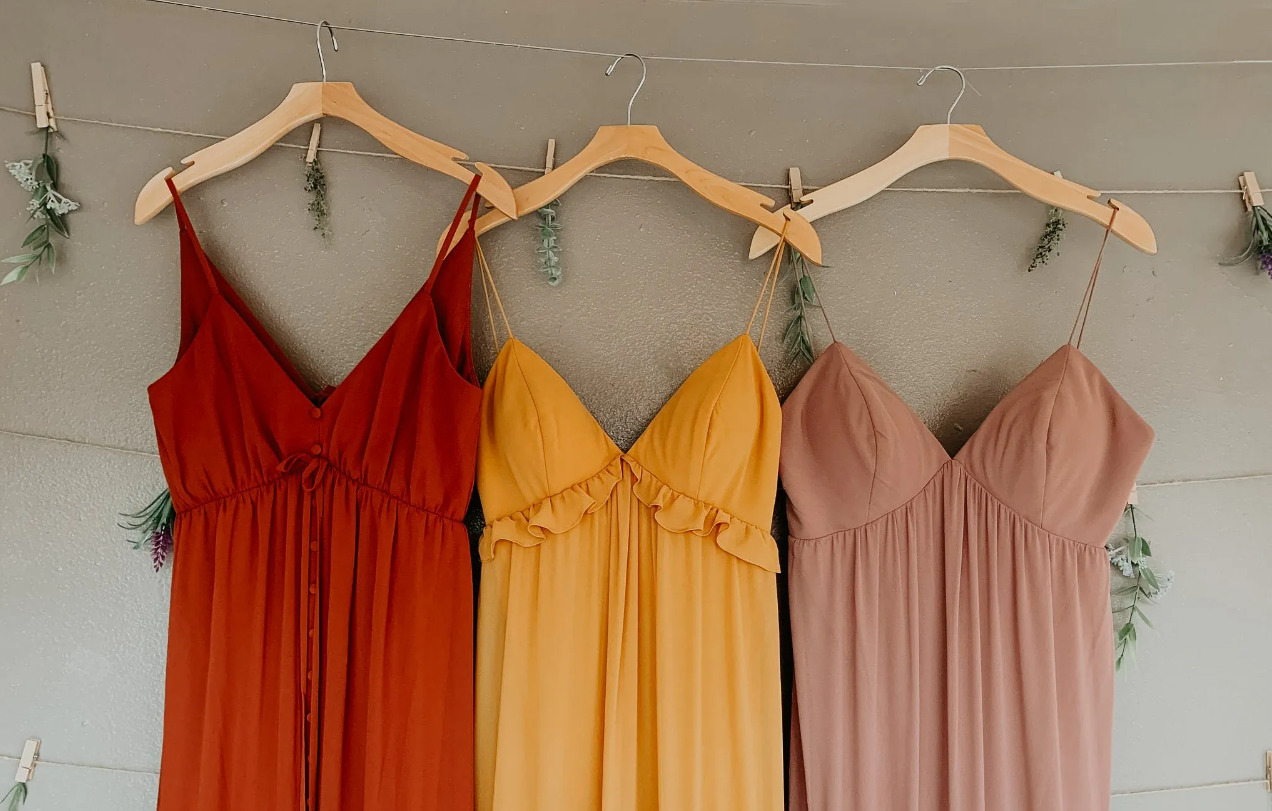 3 colorful dresses hung on hangers
