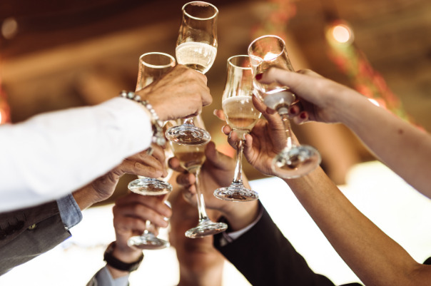 Wedding guests clink their glasses together after a well written and delivered wedding speech was delivered.