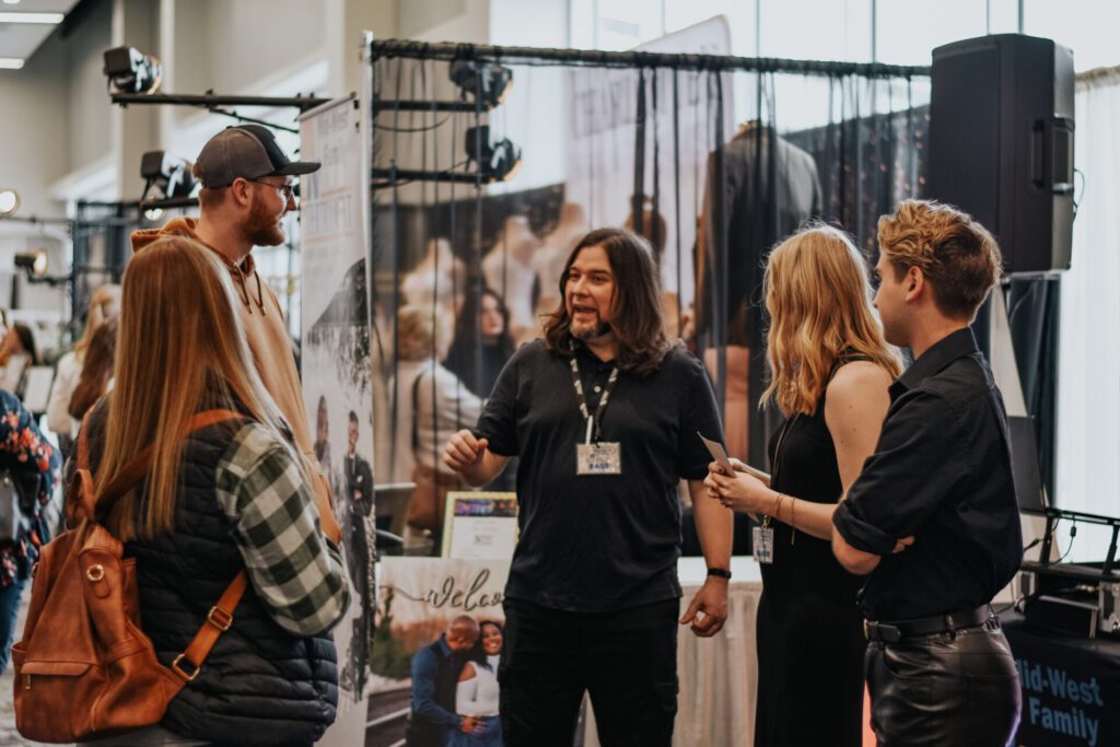 A couple interacting with a vender (Mid-West Family Entertainment) at Wedding World La Crosse.